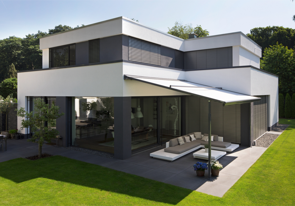 Moderne woning met overhang, grote ramen en groene tuin.