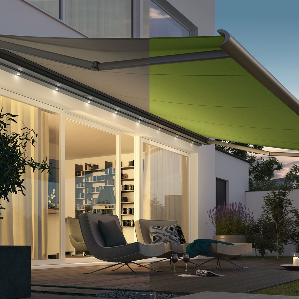 Terrassensituation mit grüner Markise und stimmungsvoller Beleuchtung unter hellen Fenstern.