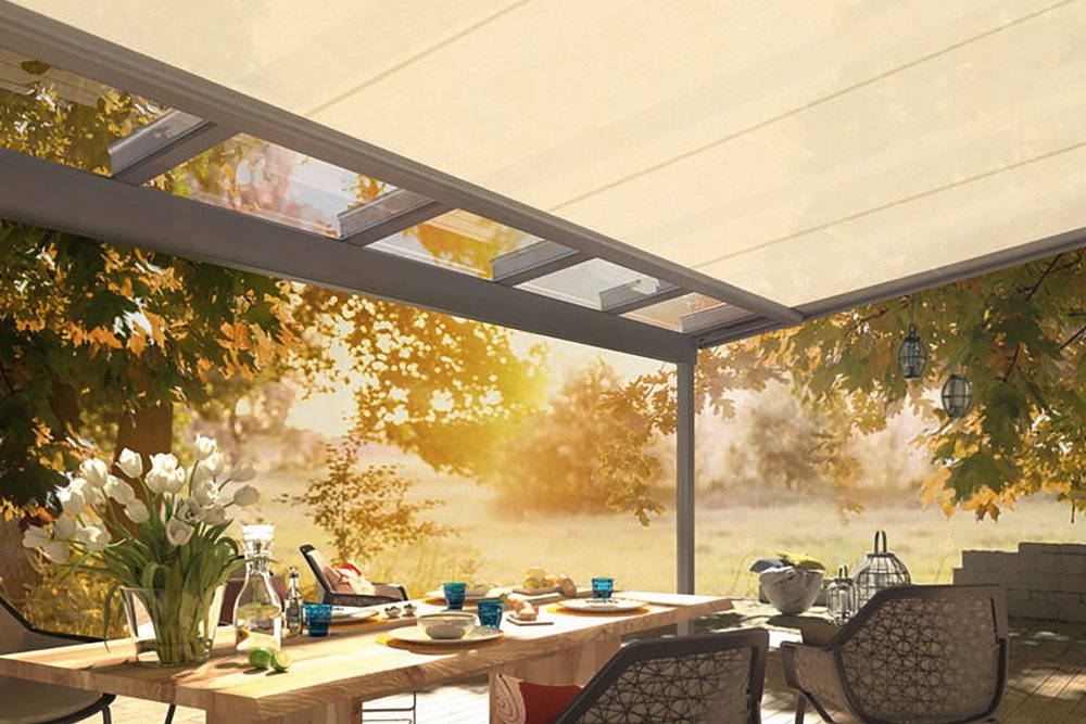 Terrassensituatie met een lichte, overkapping en een houten tafel onder een zonnescherm in een groene omgeving. Terrassensituatie met een lichte, overkapping en een houten tafel onder een zonnescherm in een groene omgeving.