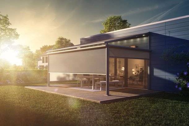 Moderne overkapping met een gesloten zonweringdoek in een groene tuin bij zonsondergang. Moderne overkapping met een gesloten zonweringdoek in een groene tuin bij zonsondergang.