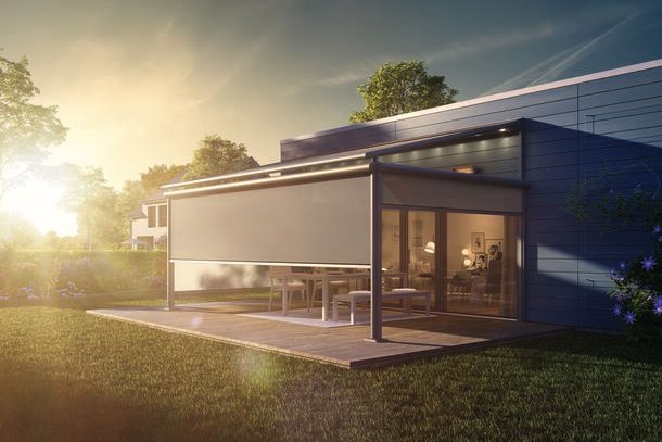 Moderne overkapping met een gesloten zonweringdoek in een groene tuin bij zonsondergang. Moderne overkapping met een gesloten zonweringdoek in een groene tuin bij zonsondergang.