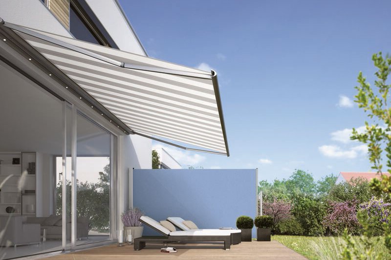 Terrassensituatie met een uitschuifbare zonnescherm en een zonnige, lichte achtergrond. Terrassensituatie met een uitschuifbare zonnescherm en een zonnige, lichte achtergrond.