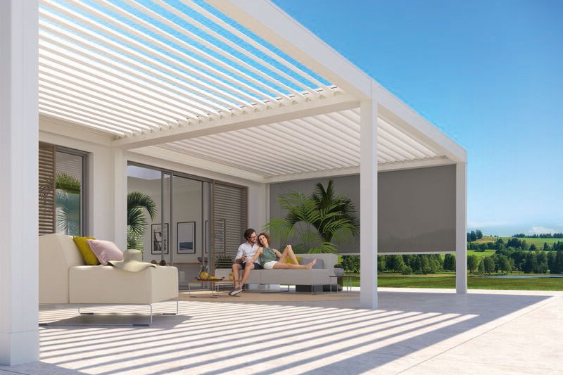Terrassensituatie onder een moderne overkapping met schaduwdoeken en uitzicht op groene velden. Terrassensituatie onder een moderne overkapping met schaduwdoeken en uitzicht op groene velden.