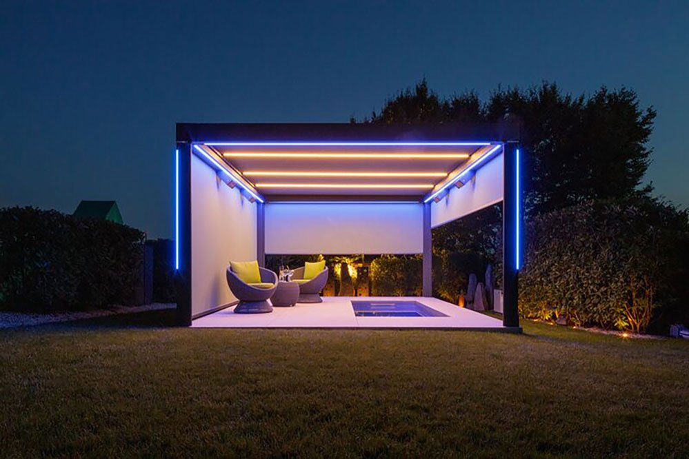 Moderne overkapping met LED-verlichting, zitplaatsen en een zwembad in een groene omgeving bij avondlicht. Moderne overkapping met LED-verlichting, zitplaatsen en een zwembad in een groene omgeving bij avondlicht.