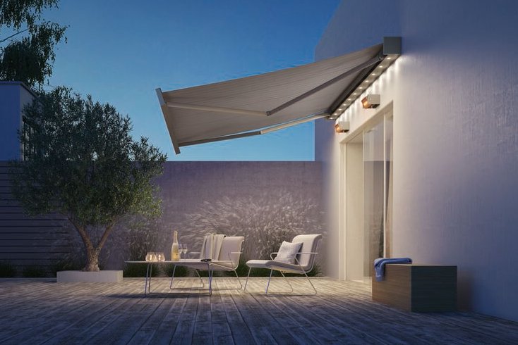 Een moderne terrassituatie met een uitgevouwen zonnescherm en zachte verlichting, onder een heldere blauwe lucht. Een moderne terrassituatie met een uitgevouwen zonnescherm en zachte verlichting, onder een heldere blauwe lucht.