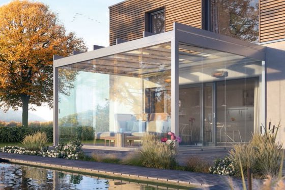 Moderne uitstraling van een woning met een glazen overkapping en een vijver in de voortuin.