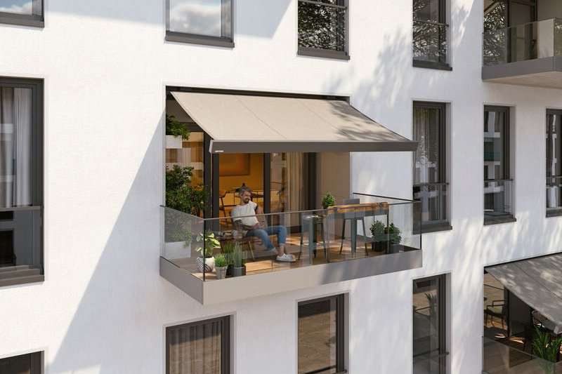 Een moderne gevel met een balkon, een zonnescherm en een zitruimte. Lichtgrijze en witte kleuren domineren. Een moderne gevel met een balkon, een zonnescherm en een zitruimte. Lichtgrijze en witte kleuren domineren.