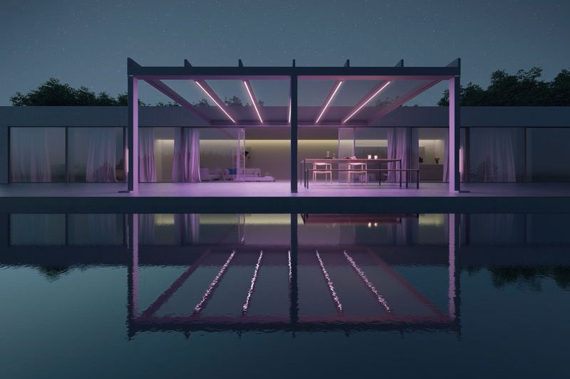 Moderne overkapping met verlichting in roze tinten, weerspiegelt in een kalm wateroppervlak.