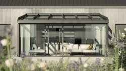 Moderne woning met glas-schiebewanden, overkappingen en een groene terrassensituatie.