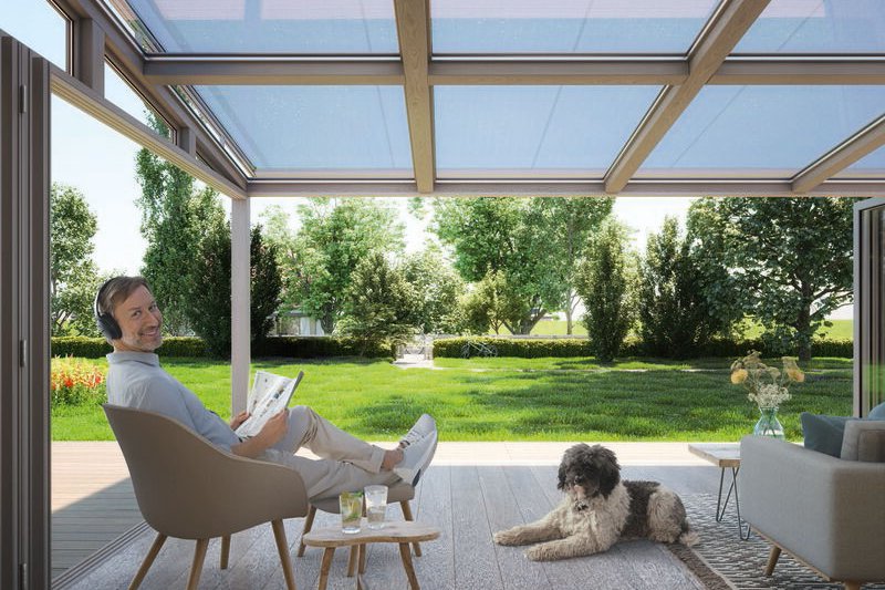 Een moderne terrasoverkapping met een lichtblauwe kleur en een houten constructie, ingericht met meubels en een hond. Een moderne terrasoverkapping met een lichtblauwe kleur en een houten constructie, ingericht met meubels en een hond.