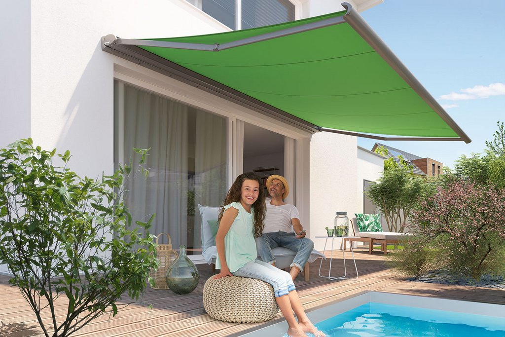 Een groene zonnescherm boven een zwembad met twee personen die ontspannen aan de rand zitten. Een groene zonnescherm boven een zwembad met twee personen die ontspannen aan de rand zitten.