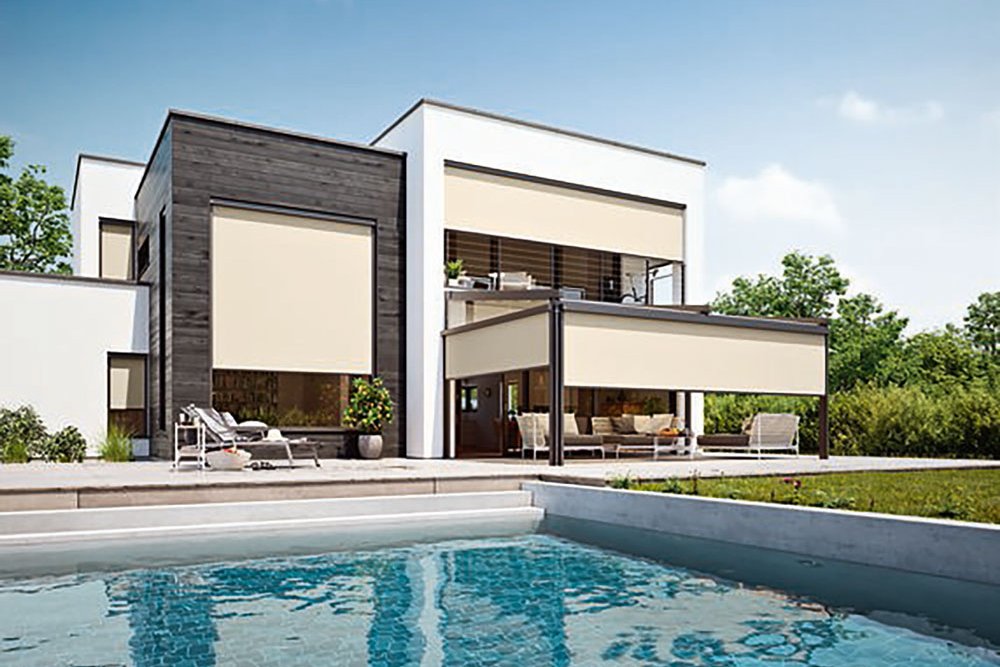 Moderne woning met overkapping en zwembad, omringd door groene tuin en blauwe lucht.