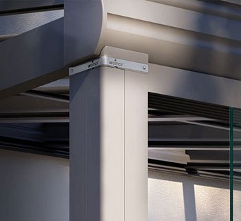 Hoek van een constructie met een lichtgekleurde metalen paal en glazen elementen.